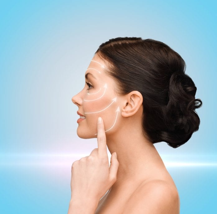 beauty, spa and health concept - smiling young woman pointing to her cheek