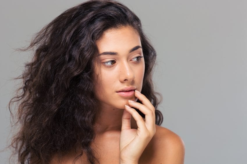 person with brown wavy hair looking to their left