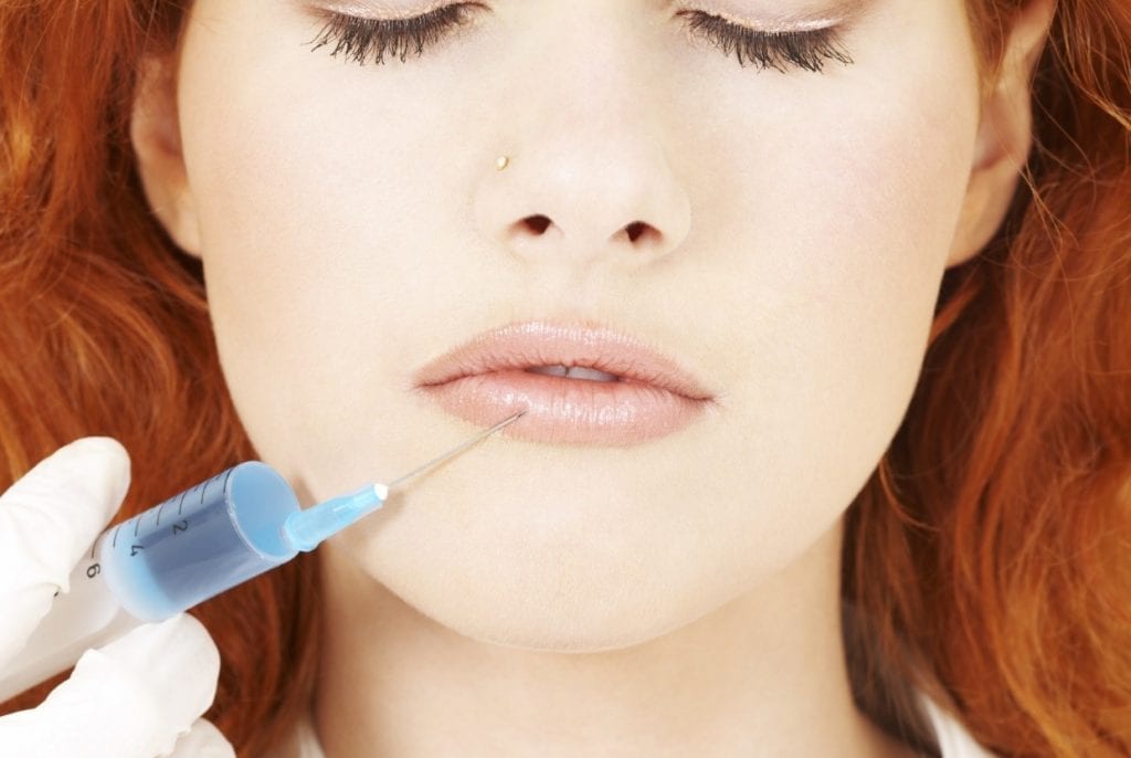 woman getting lip filler with injection