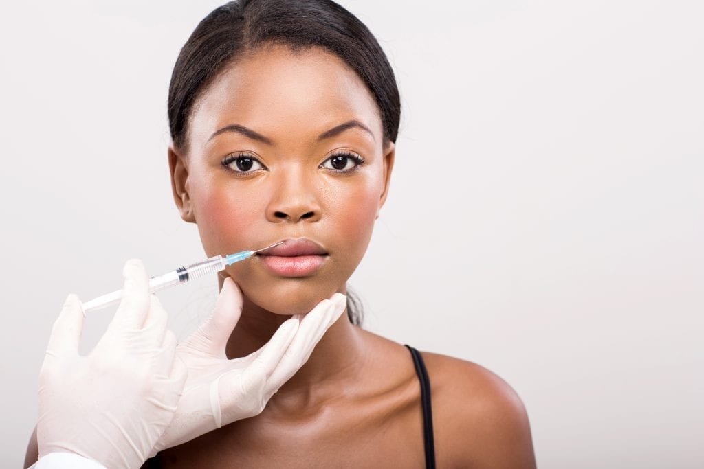 woman receiving lip filler injection