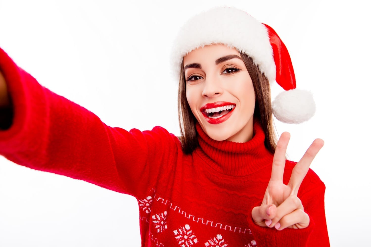 Cheerful woman in santa hat making selfie