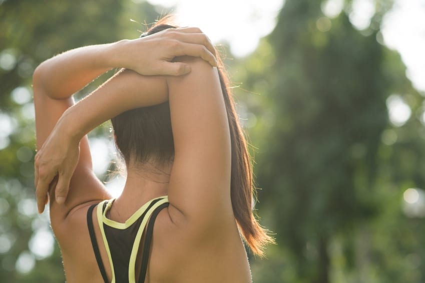 exercising after surgery - Rear view of woman stretching her arm and shoulder