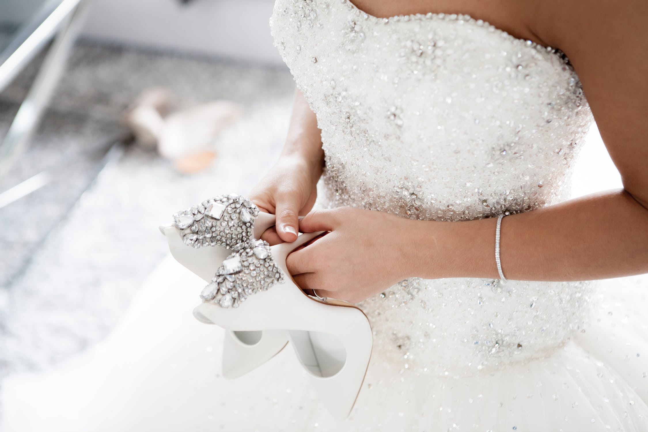 Bride holding her high heel shoes