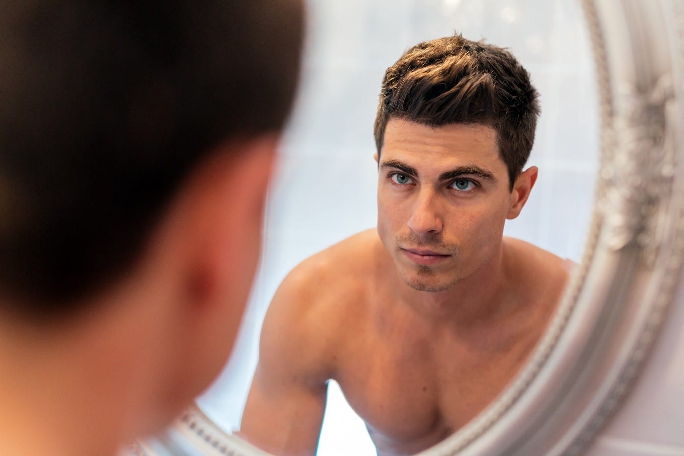 aesthetic treatments for men - man looking in the mirror