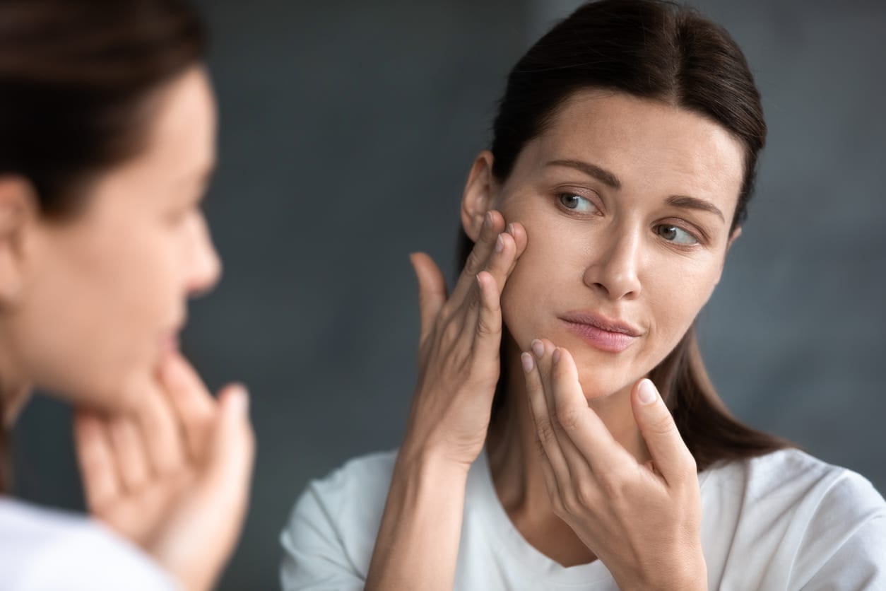 Close up unhappy woman looking in the mirror