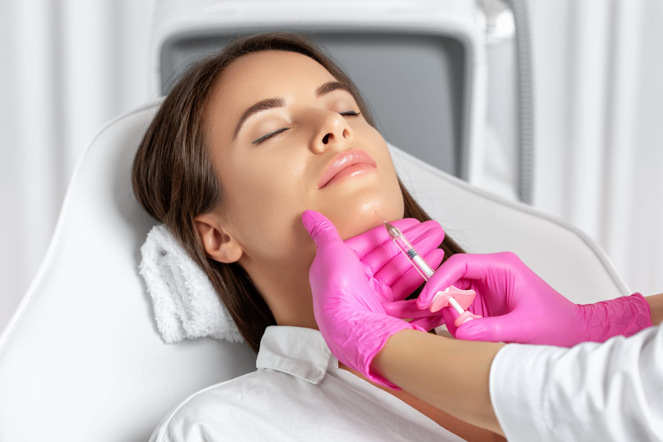 Woman having chin injected with filler