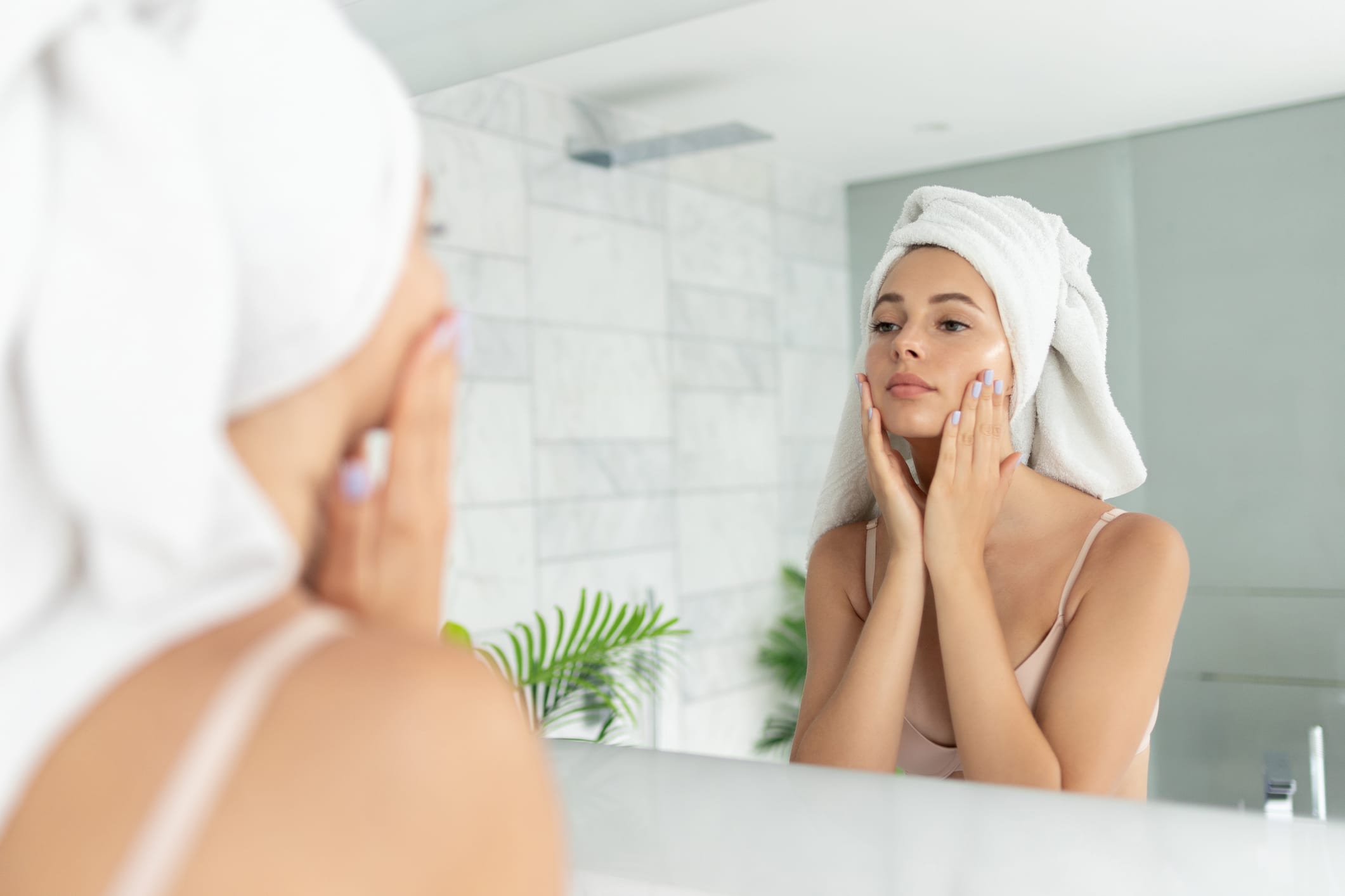 Young beautiful woman using skin face cream lotion