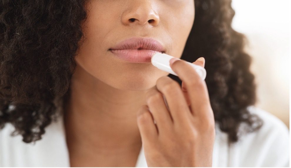 A person putting on lip balm