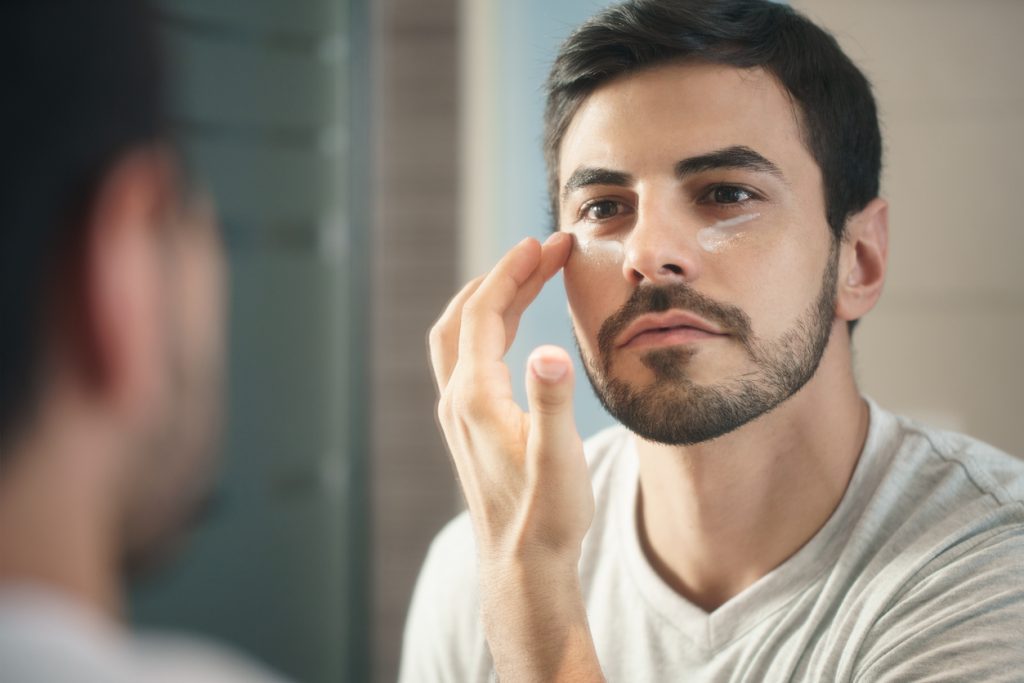 Man using anti-wrinkle products on his skin