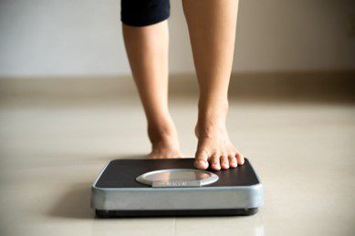 woman stepping onto scales