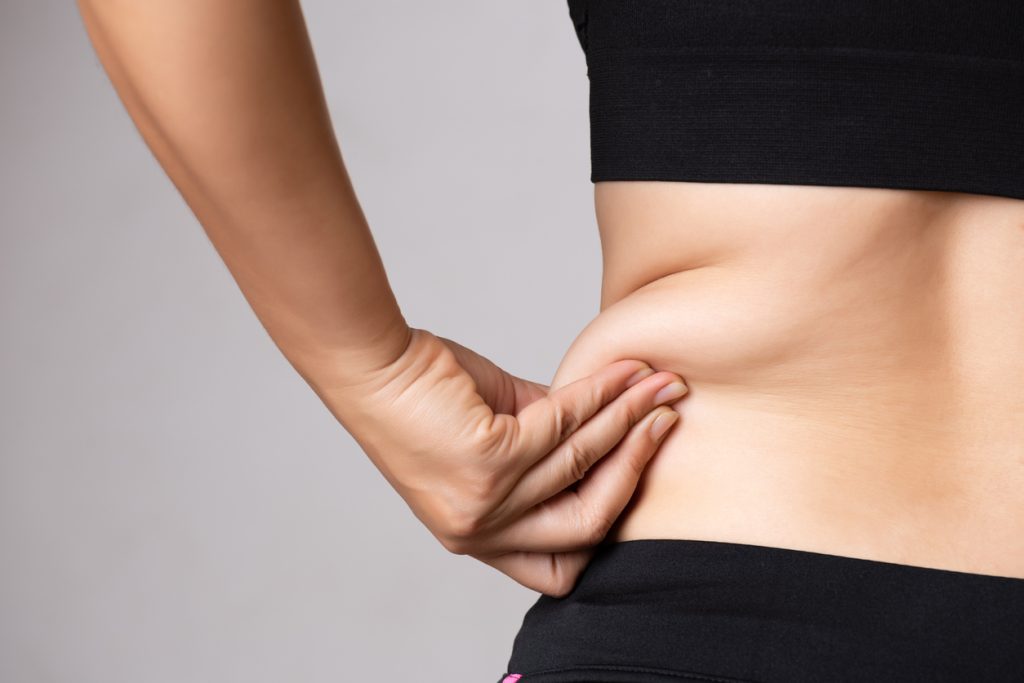 Woman pinching fat around her waist