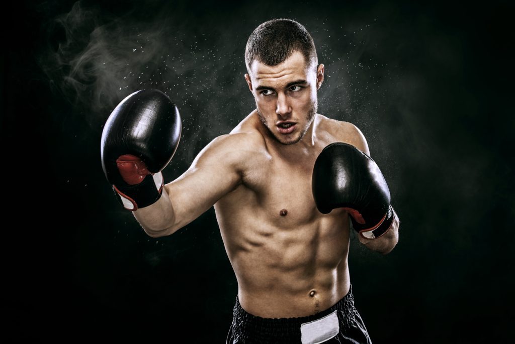 Man with boxing gloves punching the air