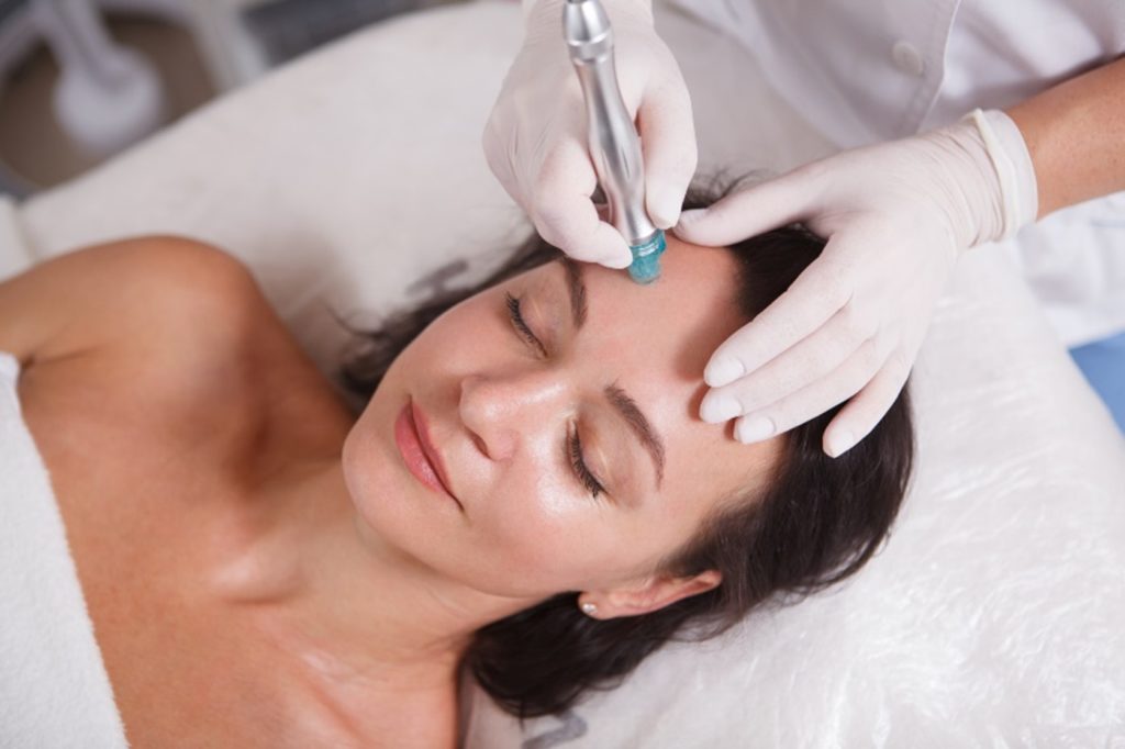 Woman receiving facial treatment to help with sun damage