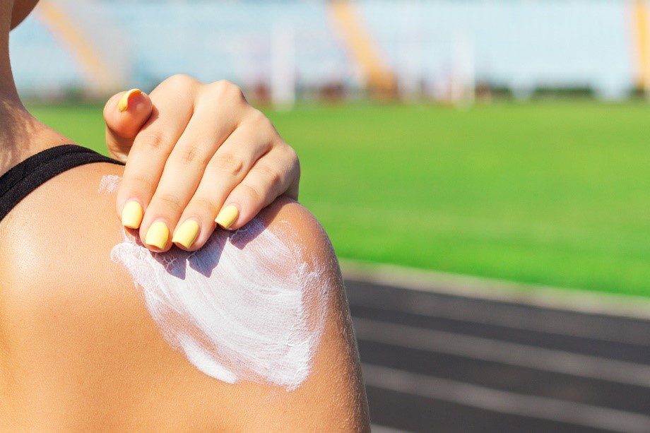 Someone rubbing sun cream into their shoulder