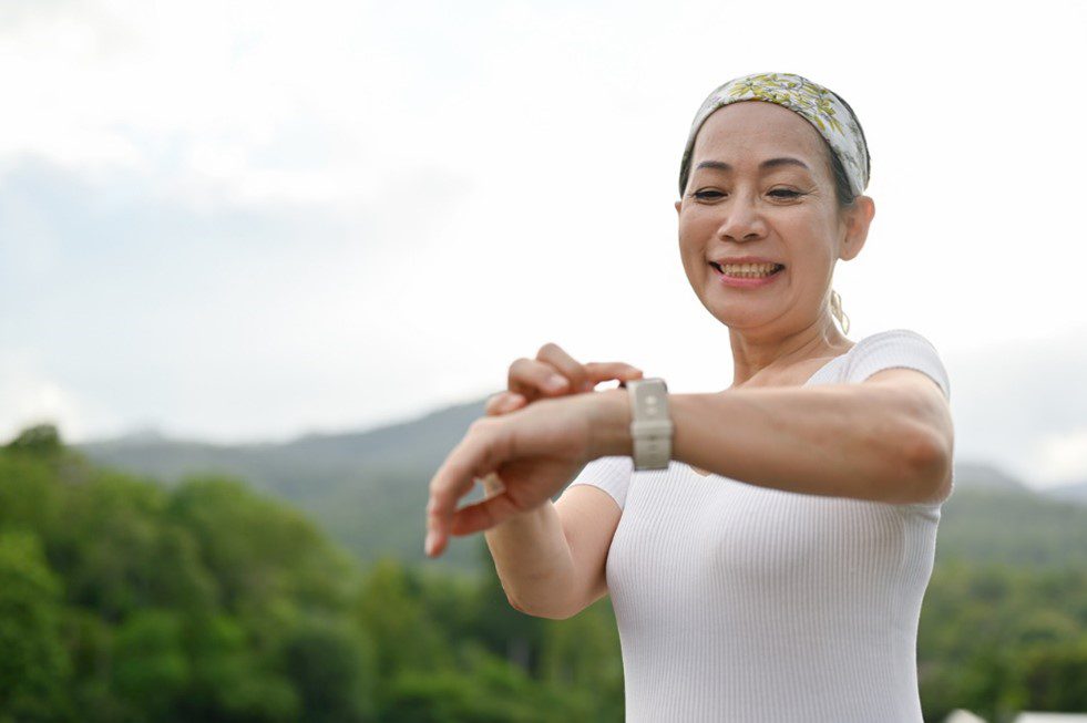 Beautiful woman in 50s exercising and checking her apple watch