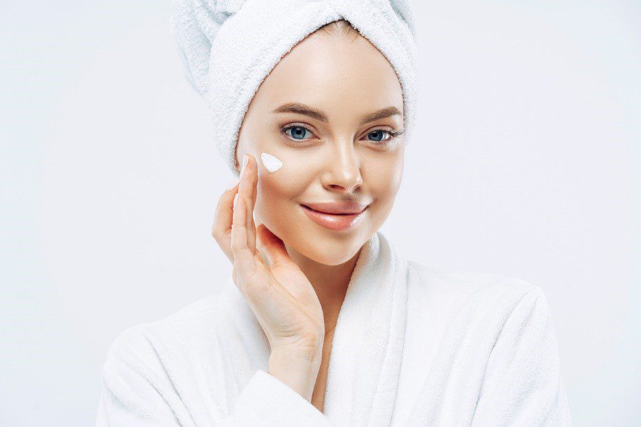 woman putting cream on face