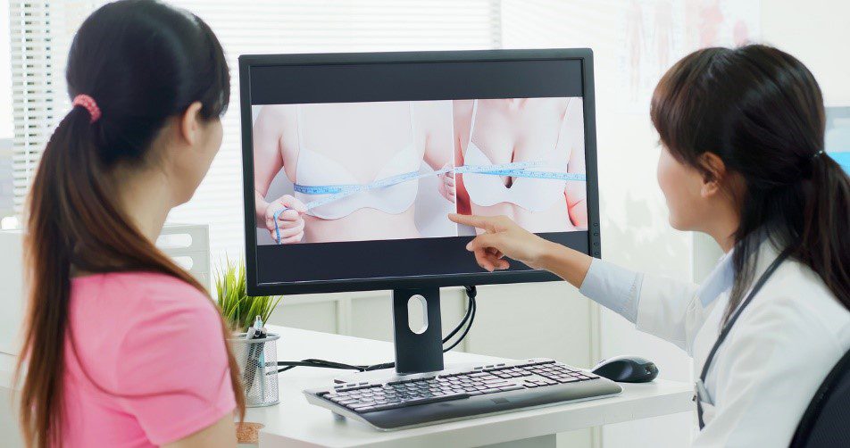 woman looking at before and after of breast surgery