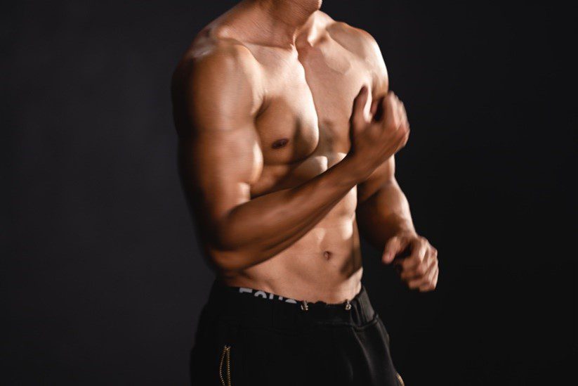 topless man showing off muscles