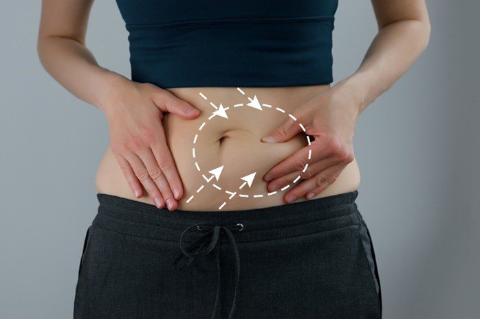 woman holding fat on stomach